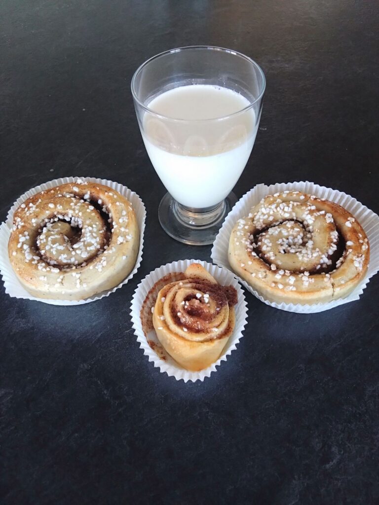 Glas med mjölk och nybakade kanelbullar