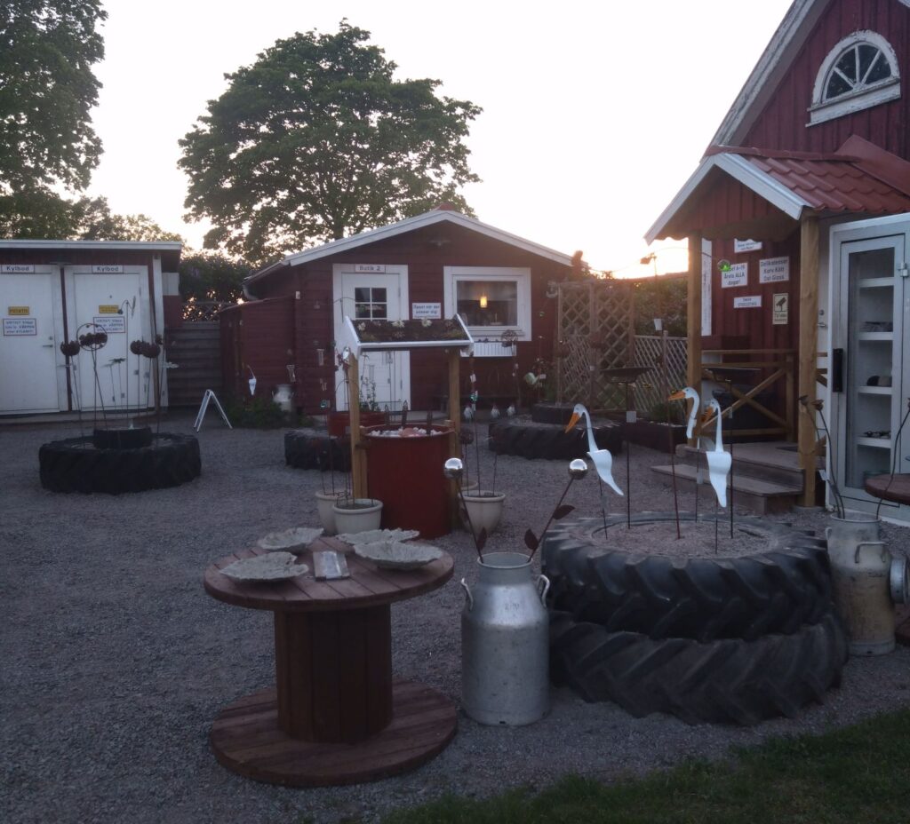 Trädgårdspynt som mashallhållare och gjutna fågelbad utanför gårdsbutikerna