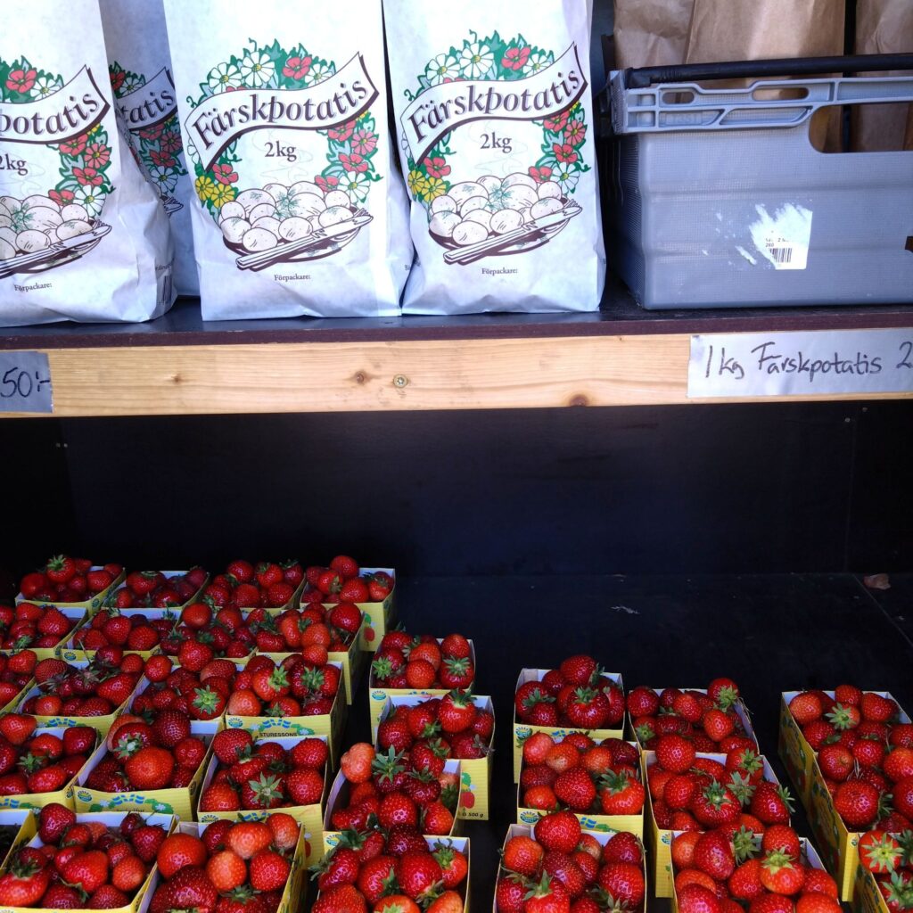 Kylboden som har potatis och nyplockade jordgubbar
